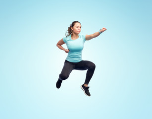 Fototapeta na wymiar happy sporty young woman jumping in fighting pose