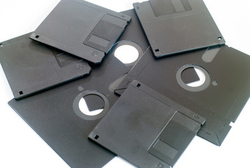 various old obsolete 5 inch and 3 inch floppy disk on white