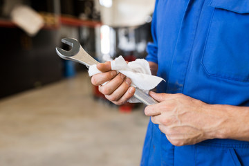 auto mechanic or smith with wrench at car workshop - Powered by Adobe