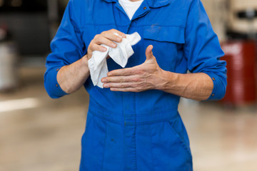 mechanic man or smith with wipe at car workshop