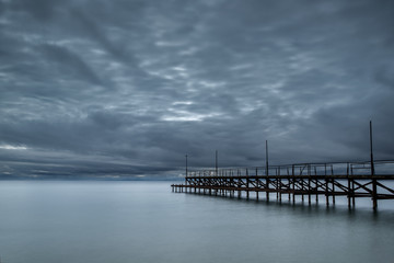 Obraz premium Dramatic cloudy sky with sea bridge in Ravda, Bulgaria. Slow motion effect.