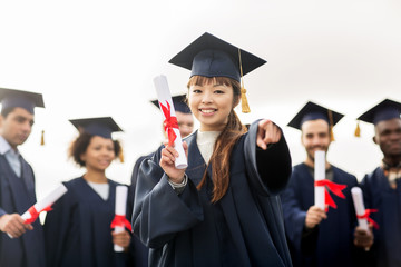 happy student with diploma pointing finger at you