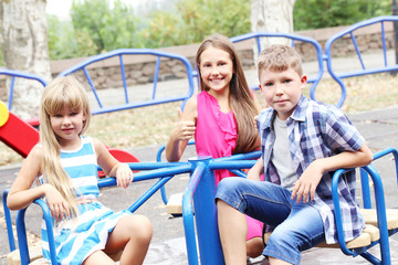 Fototapeta na wymiar Children sitting on carousel on playground