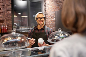 man or barman with coffee cup and customer at cafe