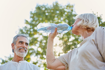 Paar Senioren trinken Flasche Wasser