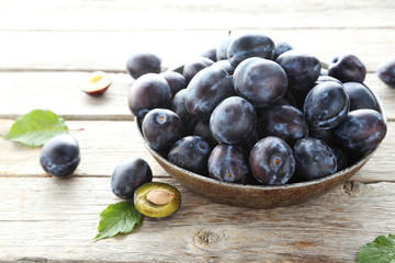 Tasty and ripe plums on grey wooden table