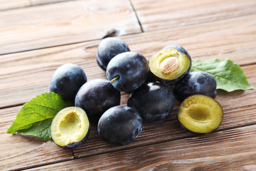 Tasty and ripe plums on brown wooden table