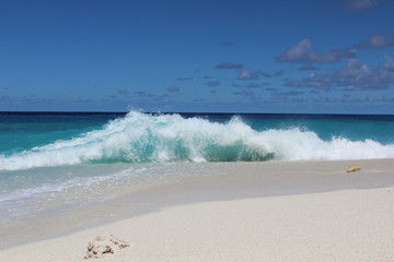 Fototapeta na wymiar Waves break on a beach in an island in the Maldives