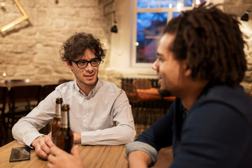 happy male friends drinking beer at bar or pub