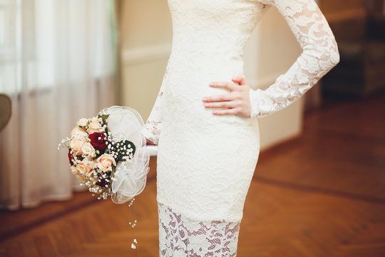 Beautiful bride in white wedding dress holding bouquet