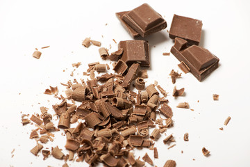 Pieces and chocolate chips on white background. Isolated.