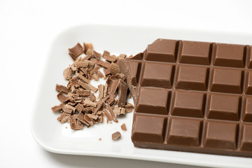 Tablet and chocolate chip on white tray. Isolated. Horizontal shoot.