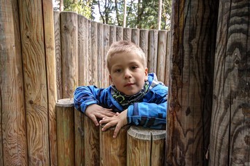 Boy looking over the wooden walls