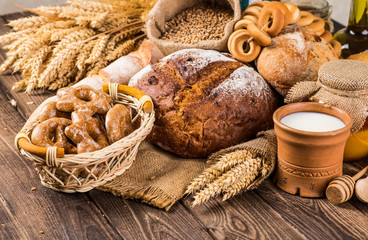 Assortment of baked bread on wooden table background