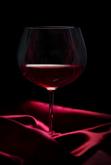 Glass of wine on red silk