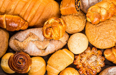 Many mixed breads and rolls shot from above.