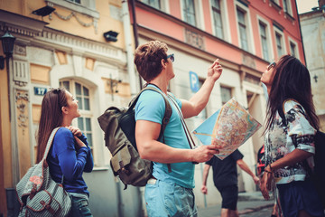 Fototapeta Multi ethnic friends tourists with map in old city obraz