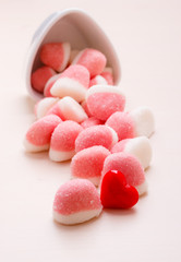 Pink jellies or marshmallows with sugar on table