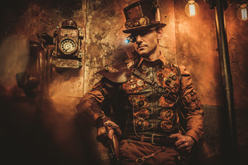 Fototapeta na wymiar steampunk style man with various mechanical devices on vintage steampunk background