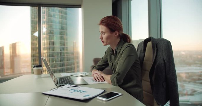 4k young business woman in modern office uses a laptop for video calls, negotiations with partners, dolly shot