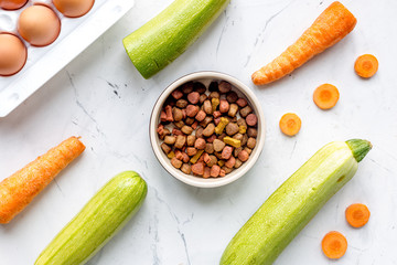 Vegetables and petfood on kitchen table background top view