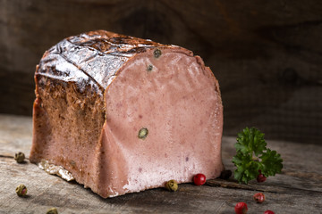 Special liver pate made from different types of meat with peppercorns on wood
