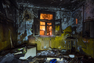 Fototapeta na wymiar Interior of the burned by fire house, burned furniture
