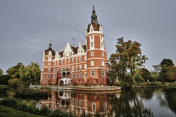 Fototapeta na wymiar moat and New Castle in the park Muskauer in Germany.