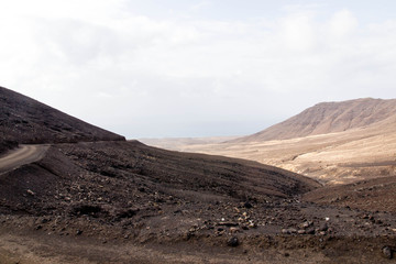 Road to Cofete Beach with mountains in the clouds - Jandia, Fuerteventura, Canary Islands, Spain