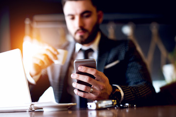 Man hand with silver ring on ring finger holding smartphone. Man in elegant stylish suit.