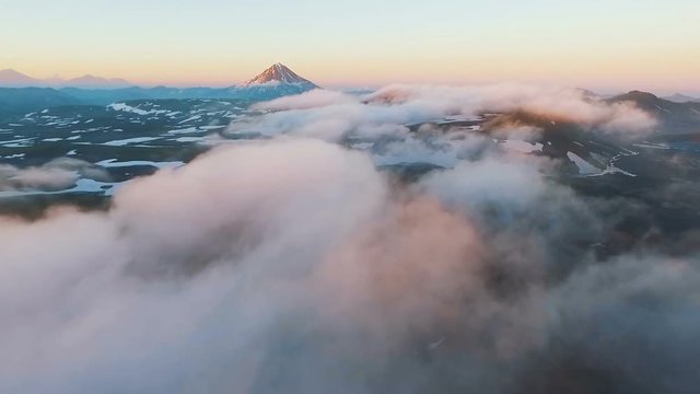 Aerial View. The airplane flies through clouds. Amazing view. Fluffy clouds float quickly