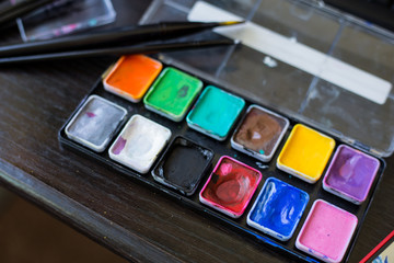 Brush to paint lies on the palette of colors, ink drawing. Drawing set for artist