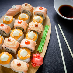 Japanese food, sushi rolls and sauce on a black background. Top view. Flat lay