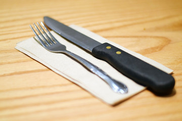 Fork and steak knife on a brown napkin