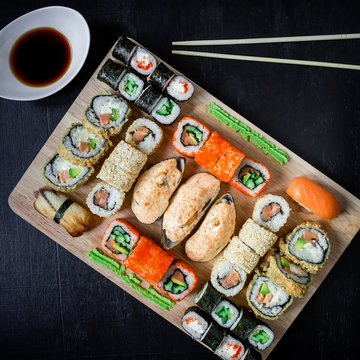 Japanese food - sushi rolls and sauce on a black background. Asian food background. Top view. Flat lay