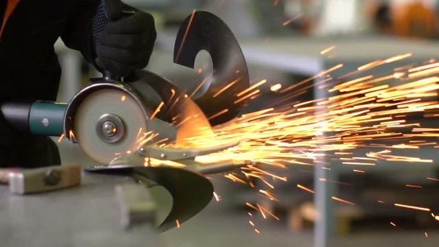 Man works circular saw. Flies of spark from hot metal. The man's hard work. Man Chlef and smooth surface. Man worked over the steel. close-up of hand and electric saws metal. Close-up of hand tool.
