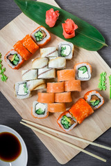 Japanese food. Sushi rolls and sauce, chopsticks on a gray background. Top view. Flat lay