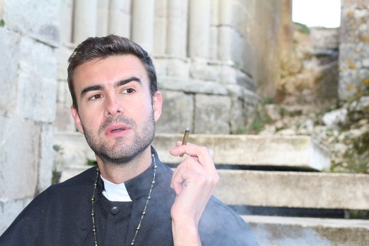 Priest smoking while taking a break
