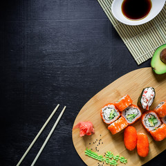 Asian food frame. Set of traditional japanese food on a black background. Sushi, avocado. Top view. Flat lay