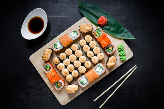 Traditional Japanese food. Japanese food - sushi rolls and sauce on a black background. Top view. Flat lay