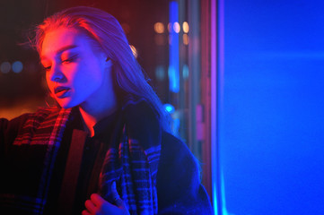 Sexy young beauty woman posing over night city dramatic red and blue neon background