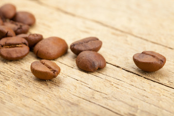 Close up shot of roasted coffee beans on old wooden table