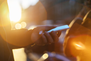 Young hipster man checking message on smartphone at sunset, Businessman calling on the cellphone, sunset light, golden light, soft focus