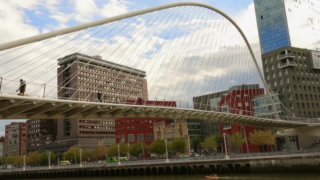 Pedestrians enjoying walk across Zubizuri bridge, breezing fresh morning air