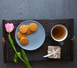Mother's Day, woman's day. tulips ,presents ,tea and sweets on wooden background