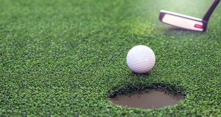 Golf ball dropping into the hole