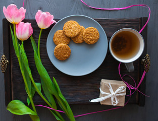 Mother's Day, woman's day. tulips ,presents ,tea and sweets on wooden background