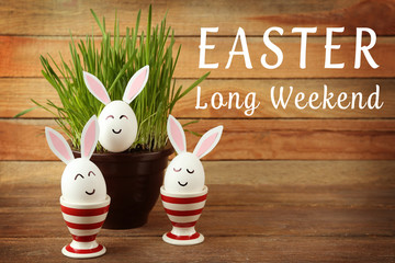 Decorated Easter eggs and pot on wooden background