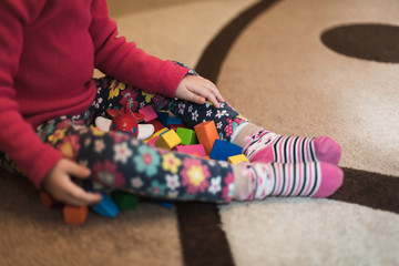 Baby play by wooden toys sitting on the carpet
