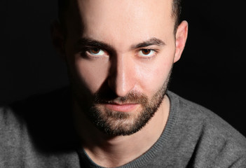 Portrait of handsome man on black background, closeup